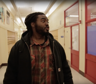 Un homme parle dans un couloir d'école